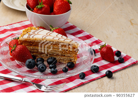 Piece of esterhazi cake decorated with fresh berries 90355627