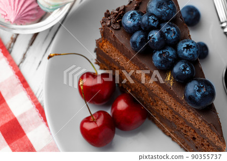 Piece of chocolate cake served with fresh berries Piece of chocolate cake served with fresh berries 90355737