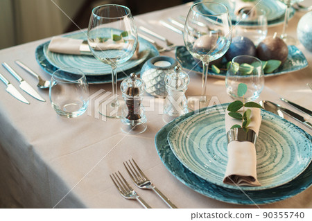 Luxury green table setting decorated with candles Luxury green table setting decorated with candles 90355740