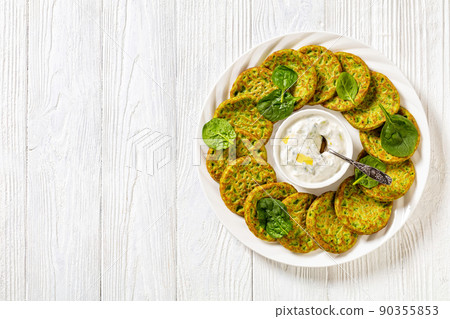 spinach pancakes on white plate with sauce spinach pancakes on white plate with sauce 90355853