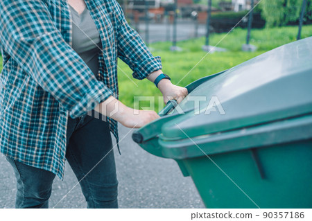 European 20s girl take out the trash can sorting garbage near a home European 20s girl take out the trash can sorting garbage near a home 90357186