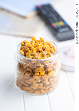 Roasted salted corn snack in jar on white table. 90357301