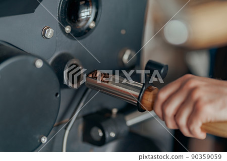 Close up of business owner hands operating modern coffee bean roasting machine Close up of business owner hands operating modern coffee bean roasting machine 90359059