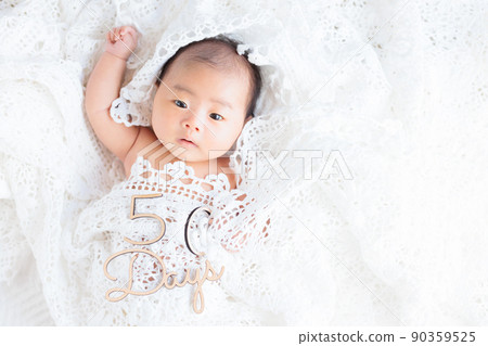 50-day-old healthy baby lace key knitting, looking at the camera, with letters, copy space 50-day-old healthy baby lace key knitting, looking at the camera, with letters, copy space 90359525