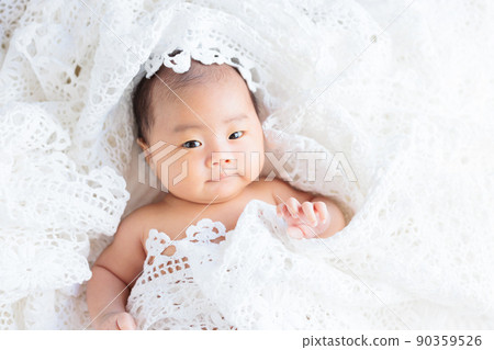 A 50-day-old baby wrapped in a race looking at the camera A 50-day-old baby wrapped in a race looking at the camera 90359526