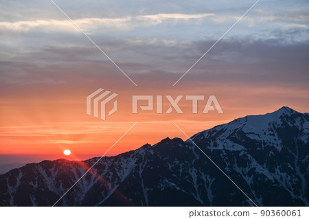 Sunset over Kasagatake seen from Nishihotakadake in spring under fine weather Mountains in the Northern Alps dyed by the setting sun 90360061