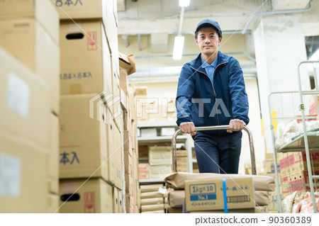 Male driver working in a warehouse Male driver working in a warehouse 90360389