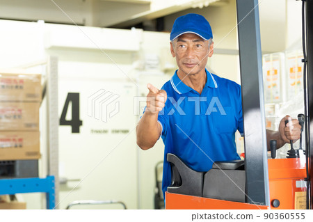 在倉庫裡駕駛叉車的中年男工 90360555