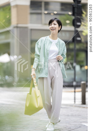 A young lady walking in the city 90361163