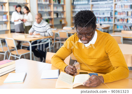 Adult african american student studying in university library Adult african american student studying in university library 90361323