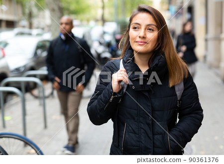 Smiling woman walking outdoors at cold day Smiling woman walking outdoors at cold day 90361376