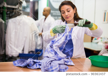 Experienced woman working in dry cleaner Experienced woman working in dry cleaner 90361437