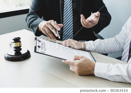 A man lawyer or a judge counseling clients about judicial justice and prosecution with scales, judges gavel, legal documents legal services concept 90363410