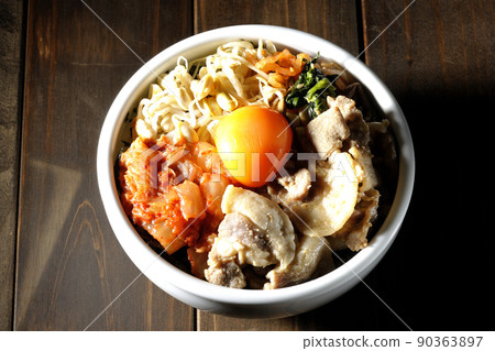 A bird's-eye view of the bibimbap bowl, which contains a lot of ingredients such as bean sprouts, kimchi, and pork. 90363897