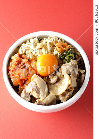 A bird's-eye view of the bibimbap bowl, which contains a lot of ingredients such as bean sprouts, kimchi, and pork. 90363912