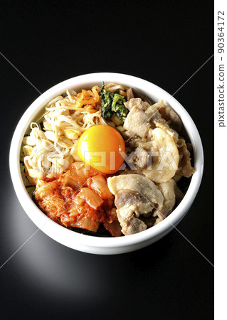 黑色背景中包含豆芽、泡菜和豬肉等大量配料的拌飯碗的鳥瞰圖。 黑色背景中包含豆芽、泡菜和豬肉等大量配料的拌飯碗的鳥瞰圖。 90364172