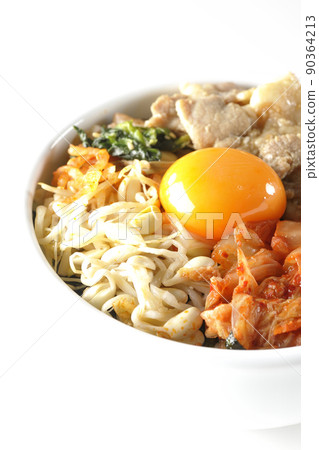 Bibimbap bowl with lots of ingredients such as bean sprout namul, kimchi, and pork taken on a white background Bibimbap bowl with lots of ingredients such as bean sprout namul, kimchi, and pork taken on a white background 90364213