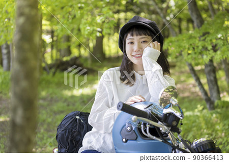 騎自行車的女孩形象:一位騎著摩托車在樹林裡的年輕女子 騎自行車的女孩形象:一位騎著摩托車在樹林裡的年輕女子 90366413