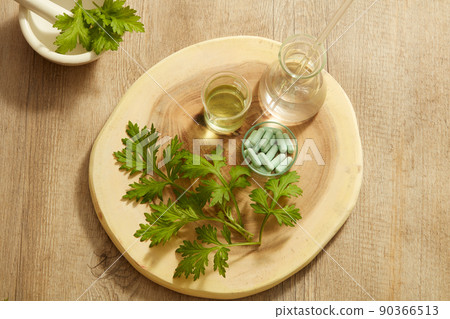 Top view of mugwort decorated with mortar and pestile wooden dish in wooden background for exfoliate advertising	 90366513