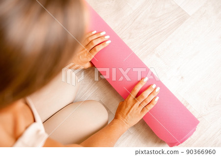 Well looking middle aged woman with long hair, fitness instructor in beige sportswear, doing stretching and pilates on yoga mat in the gym. Healthy lifestyle, harmony. Female fitness yoga meditation. Well looking middle aged woman with long hair, fitness instructor in beige sportswear, doing stretching and pilates on yoga mat in the gym. Healthy lifestyle, harmony. Female fitness yoga meditation. 90366960
