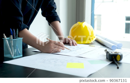Architects or engineers working construction and drawing construction plans, printing, writing on-site construction sites. Home design concept Architects or engineers working construction and drawing construction plans, printing, writing on-site construction sites. Home design concept 90367131