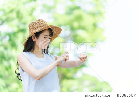 Women spraying sunscreen and insect repellent (problems / arms) Women spraying sunscreen and insect repellent (problems / arms) 90369597