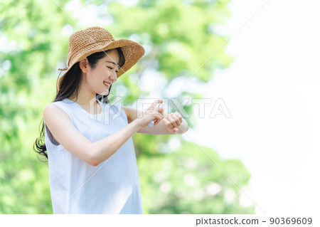 Women spraying sunscreen and insect repellent (smiles, hands) Women spraying sunscreen and insect repellent (smiles, hands) 90369609