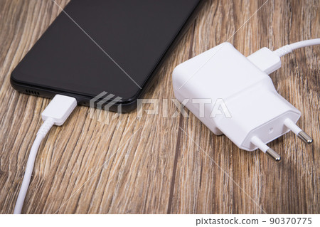 Black smartphone with charger. Various devices charging concept 90370775