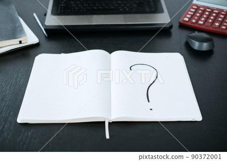 Question mark in a notepad on the background of a laptop and a calculator 90372001