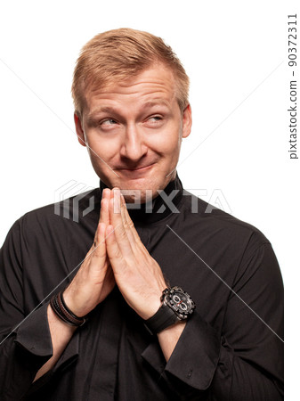Young blond man in a black shirt, watches and bracelet is making faces, isolated on a white background Young blond man in a black shirt, watches and bracelet is making faces, isolated on a white background 90372311