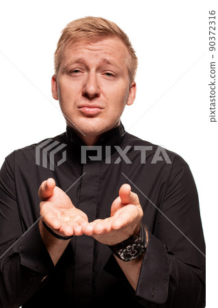 Young blond man in a black shirt, watches and bracelet is making faces, isolated on a white background 90372316