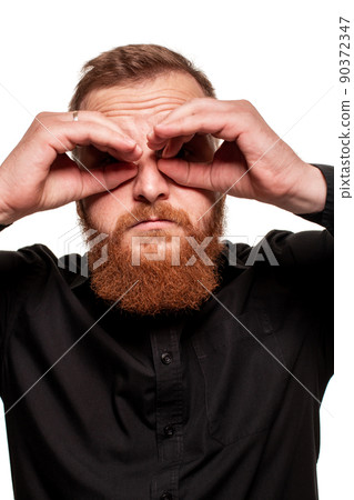 Portrait of a young, chubby, redheaded man in a black shirt making faces at the camera, isolated on a white background Portrait of a young, chubby, redheaded man in a black shirt making faces at the camera, isolated on a white background 90372347