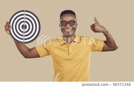 Happy African American man showing shooting target, smiling and giving thumbs up 90372348