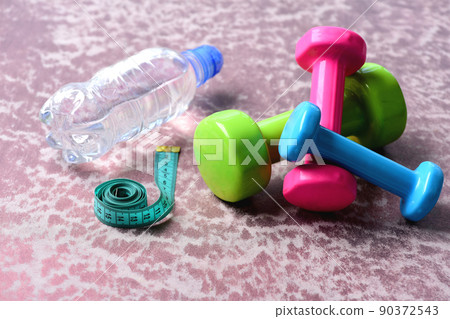 Barbells in green, pink and cyan color near bottle Barbells in green, pink and cyan color near bottle 90372543