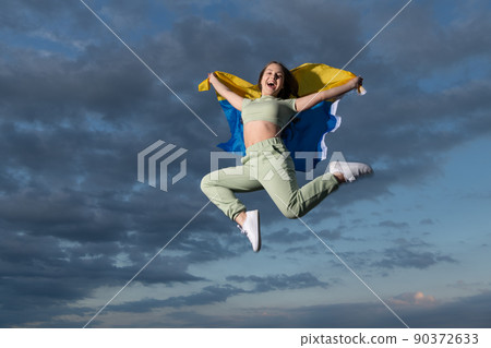 happy teen girl jump with national ukrainian flag of ukraine, happiness and freedom happy teen girl jump with national ukrainian flag of ukraine, happiness and freedom 90372633