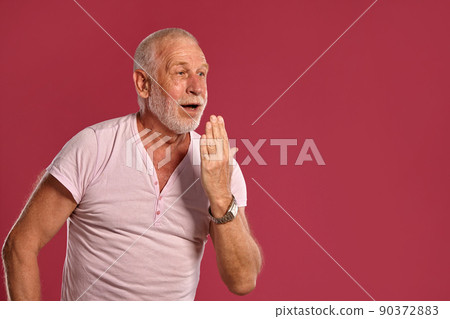 Handsome mature man posing against a pink studio background. 90372883