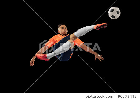 Dynamic portrait of professional male football soccer player in motion isolated on dark background. Concept of sport, goals, competition, hobby, achievements Dynamic portrait of professional male football soccer player in motion isolated on dark background. Concept of sport, goals, competition, hobby, achievements 90373485
