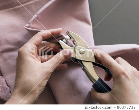 Setting a snap in pink french terry fabric with a piercing riveting tool 90373732