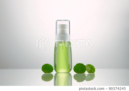 Cosmetic bottle containers with centella asiatica (gotu kola) leaves on table. Blank label for branding mock-up. Natural beauty product concept. Cosmetic bottle containers with centella asiatica (gotu kola) leaves on table. Blank label for branding mock-up. Natural beauty product concept. 90374245