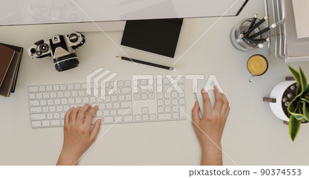 Overhead shot, A female hands typing on computer keyboard on a modern office workspace 90374553