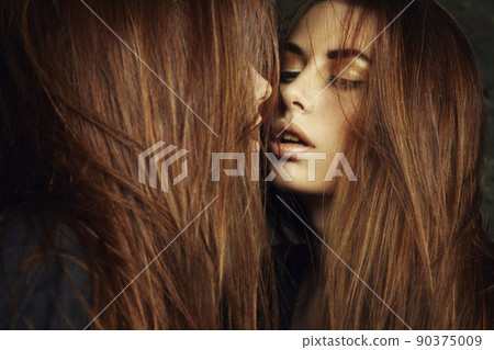 Beautiful young woman near a mirror 90375009