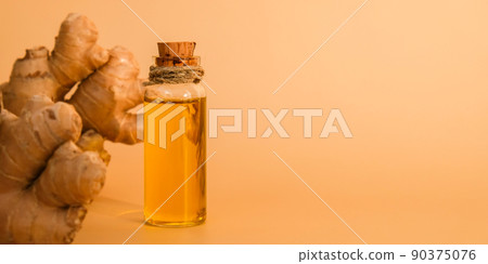 Glass bottle of essential ginger oil, ginger root on beige background. Healthy food eating concept. Zingiber officinale Essential oil. Natural cosmetics ingredients for skincare, body and hair care Glass bottle of essential ginger oil, ginger root on beige background. Healthy food eating concept. Zingiber officinale Essential oil. Natural cosmetics ingredients for skincare, body and hair care 90375076