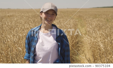 young woman works countryside tablet. farming concept. back view. young ears golden wheat farm. agriculture concept. farmer walks along rural road smart farm. cultivation of wheat by rural workers young woman works countryside tablet. farming concept. back view. young ears golden wheat farm. agriculture concept. farmer walks along rural road smart farm. cultivation of wheat by rural workers 90375104
