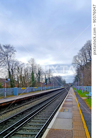 View of an empty platform on the railway on a cloudy day. 90376047