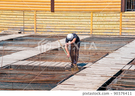 worker at a fish farm maintain aquaculture installations 90376411
