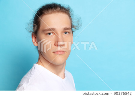 Closeup portrait of young man, student posing isolated on blue background. Human emotions, facial expression concept. Trendy colors 90376842