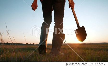 agriculture. farmer with a shovel walk in the field. agriculture business harvesting of a farmer man with shovel a walk to work in the field. business sun natural roducts soil harvest 90377747