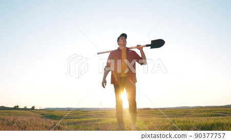 agriculture. farmer with a sun shovel walk in the field. agriculture business harvesting portrait of a farmer man with shovel a walk to work in the field. business natural products harvest soil 90377757