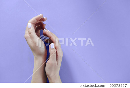 Woman with manicure placing hands over very peri background Woman with manicure placing hands over very peri background 90378337