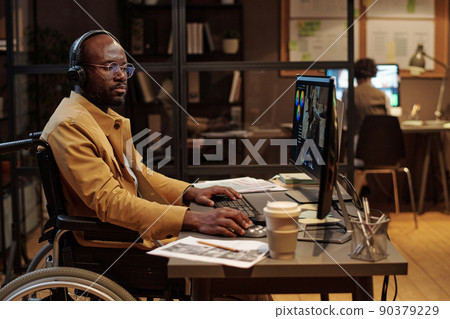 African man in wheelchair editing a video using post production software wearing headphones African man in wheelchair editing a video using post production software wearing headphones 90379229